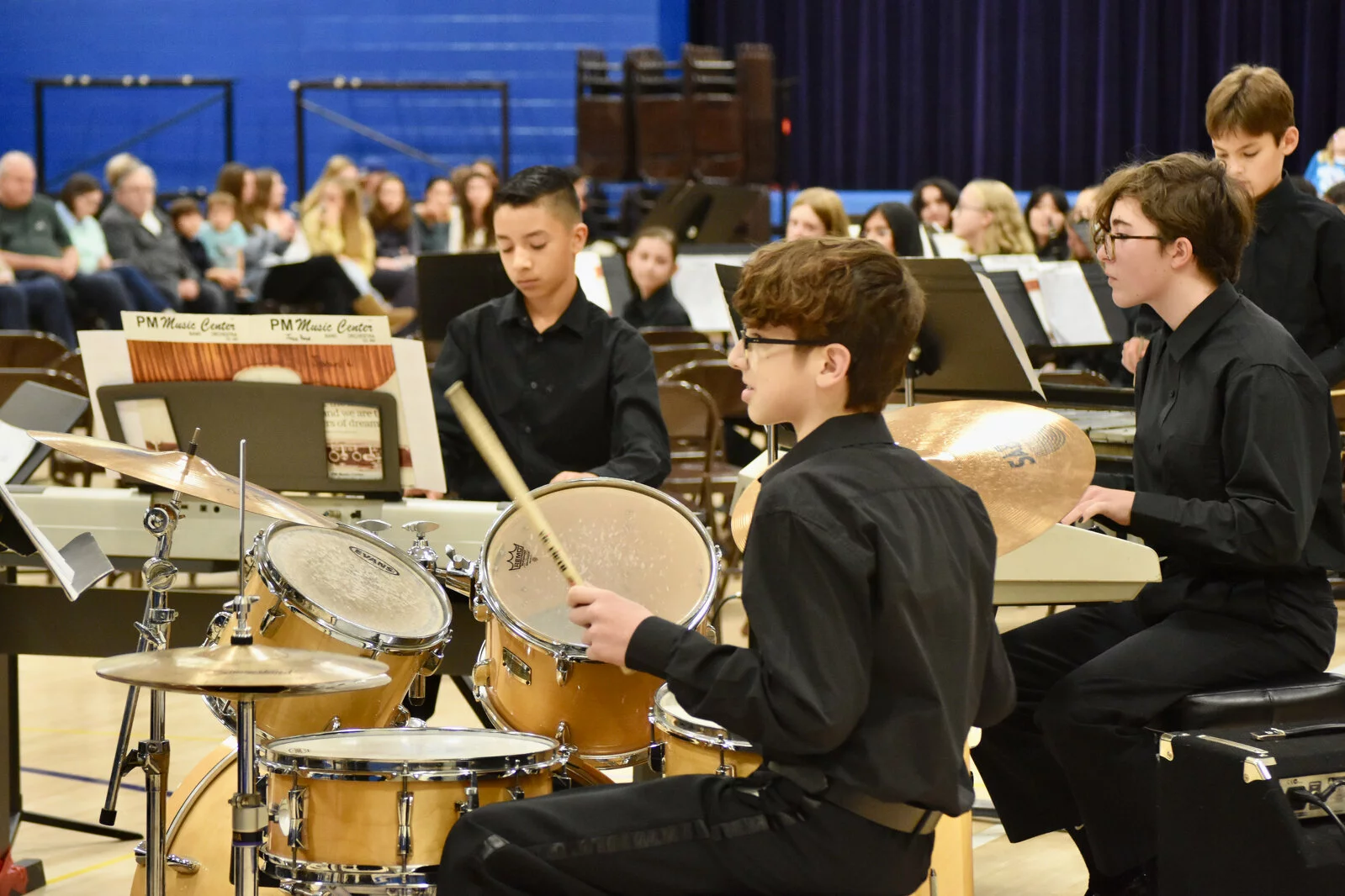 Drummer playing drum kit during fall band concert